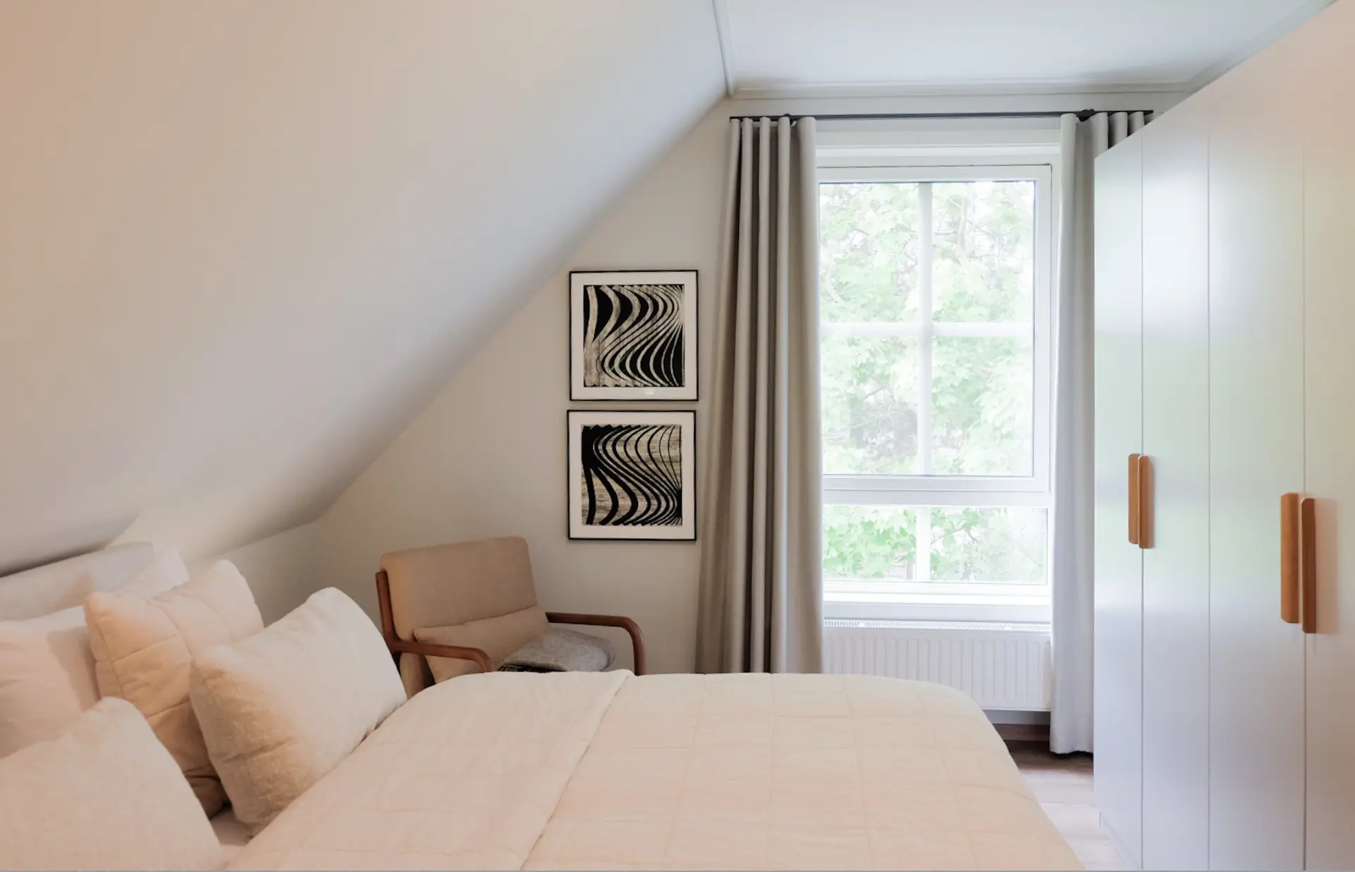Drittes Schlafzimmer mit heller Einrichtung und Kunst an der Wand
