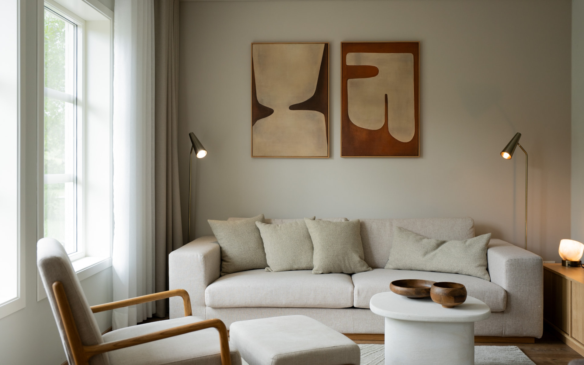 Helles Wohnzimmer mit Sofa, Kunst und Leselampen